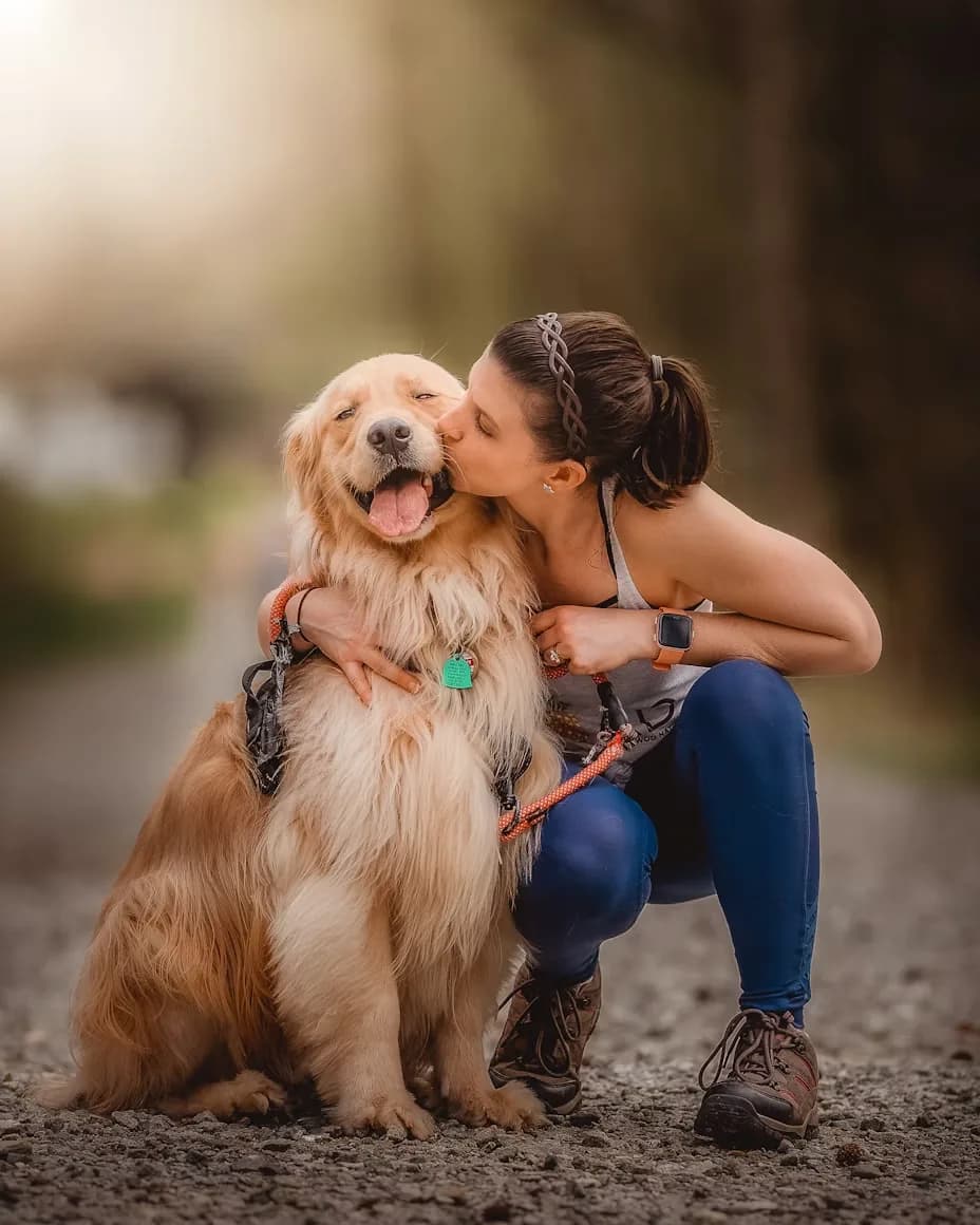 A woman kissing her golden retriever at KOVA Sonoma
